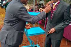 the-principal-serving-the-anniversary-cake-to-mr-jm-mutugi-the-first-bom-chairman-1972-1988